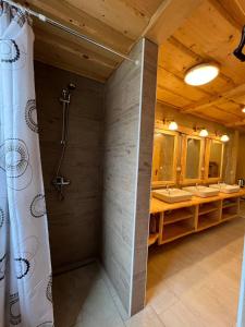 a bathroom with three sinks and a shower in it at Tree house - Ethno holistic village Apače in Apače