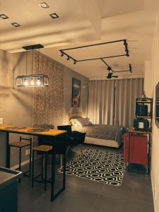 a bedroom with a bed and a desk and a kitchen at Studio Industrial in Niterói