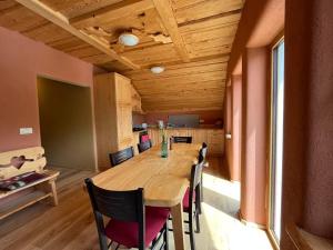 a dining room with a wooden table and chairs at Tree house - Ethno holistic village Apače in Apače