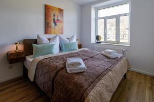 a bedroom with a large bed with towels on it at Apartement Elsterblick in Gera