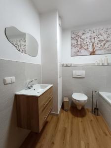 a white bathroom with a sink and a toilet at Apartement Elsterblick in Gera