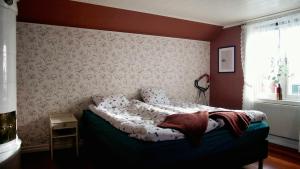 a bedroom with a bed with a blanket on it at Storgatan 30 i centrala Vimmerby in Vimmerby