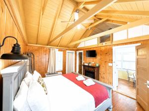 a bedroom with a bed in a room with wooden walls at Cottage 12 - King Bed Child Loft w Twin Private Bath Kitchenette Pets Allowed Fee applies in Wolfeboro