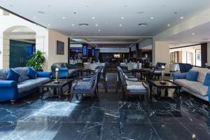 a hotel lobby with blue couches and tables at Barceló Aruba - All Inclusive in Palm-Eagle Beach