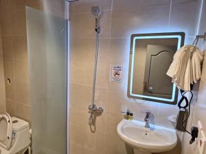 a bathroom with a shower and a sink and a mirror at Hotel Lujain Al Dhahabi Star in Al ‘Awālī