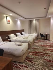 a row of beds in a hotel room at Hotel Lujain Al Dhahabi Star in Al ‘Awālī
