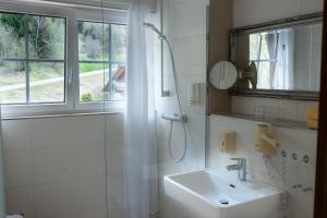 a white bathroom with a sink and a shower at Hotel & Restaurant Grüner Baum - Die Grüne Oase Am Feldberg in Feldberg +96 photos