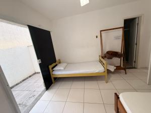 a small bedroom with a bed and a mirror at Pousada canto do forte in Cabo Frio