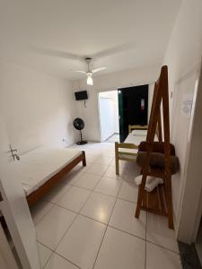 a room with two beds and a chair in it at Pousada canto do forte in Cabo Frio