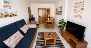 a living room with a blue couch and a table at Apartamento Sunrise in Altura