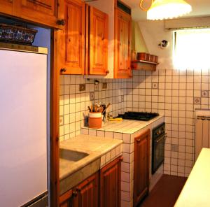 cocina con armarios de madera, fregadero y nevera en Il Mulino Di Pianello, en Molezzano