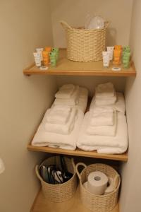 a bathroom with three shelves with towels and baskets at The Perch at Eagle Harbor in Bainbridge Island +44 photos