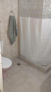 a bathroom with a shower curtain and a toilet at Hospedaje "Doña Tomasa" -A 15 minutos del aeropuerto -Parking in Ezeiza