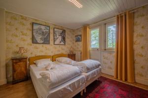 a bedroom with two beds and a window at Chalet Ecureuil Family retreat w/ Garden & Fireplace - Happy Rentals in Chamonix