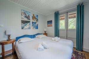 a bedroom with a large white bed with blue curtains at Chalet Ecureuil Family retreat w/ Garden & Fireplace - Happy Rentals in Chamonix +17 photos
