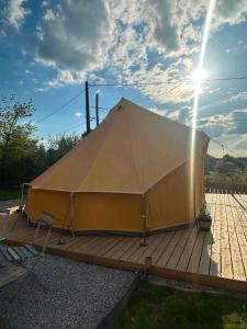 a large tent sitting on a wooden deck at Ardennes Prestige Glamping in La Neuville-aux-Joûtes