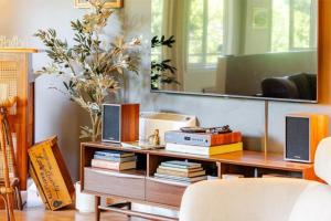 a living room with a table with books and a mirror at Evergreen Escape in Felton +39 photos