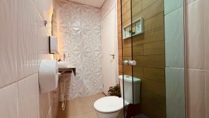 a bathroom with a toilet and a sink at POUSADA DONATELLA Modernidade e conforto para noites tranquilas in Paranaguá +36 photos