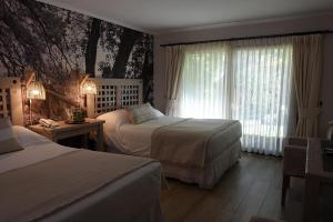 a hotel room with two beds and a window at Casa Bosque Lodge in San José de Maipo +19 photos