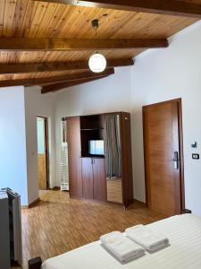 a bedroom with a bed and a tv and wooden ceilings at Kompleksi Jakaj in Velipojë