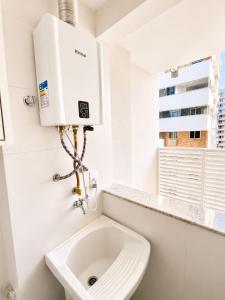 a white bathroom with a toilet and a sink at SkyHero Apê in Vila Velha +10 photos