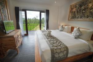 a bedroom with a large bed and a balcony at The Alugara Suite & Spa in Tegalalang +38 photos
