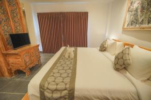 a bedroom with a large bed and a television at The Alugara Suite & Spa in Tegalalang
