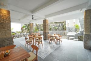 a restaurant with tables and chairs and a patio at The Alugara Suite & Spa in Tegalalang