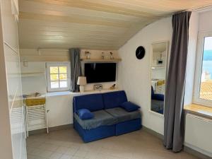 a living room with a blue couch and a television at VRBNIK OLD CITY LOFT in Vrbnik