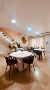 a large room with tables and chairs and stairs at POUSADA DONATELLA Modernidade e conforto para noites tranquilas in Paranaguá