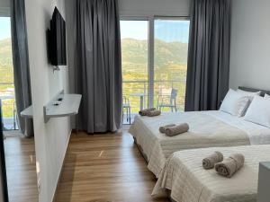 a hotel room with two beds and a balcony at Irene's rooms in Himare