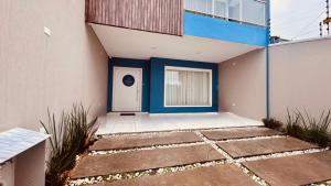 a house with a blue door and a window at POUSADA DONATELLA Modernidade e conforto para noites tranquilas in Paranaguá