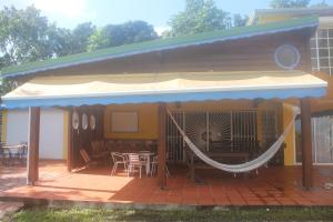 a patio with a hammock on a house at Concept Kreyol in Sainte-Rose