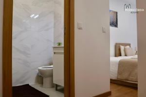 a bathroom with a toilet and a bed at Misericórdia Rooms in Guarda +124 photos