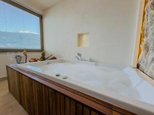 a large bath tub in a bathroom with a large window at Adasya Hotel in Kaş +68 photos