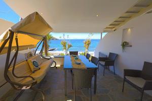 a room with a couch and a table and the ocean at Lontos Luxury Seaside House in Flampouria