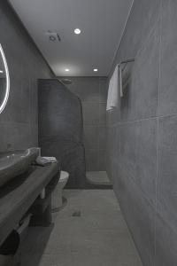 a bathroom with a toilet and a sink at Lontos Luxury Seaside House in Flampouria +11 photos