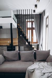 a living room with a couch and a staircase at Apartament Centrum Żywiec - GROJEC in Żywiec +32 photos