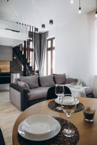 a living room with a couch and a table with wine glasses at Apartament Centrum Żywiec - GROJEC in Żywiec