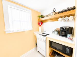 a small kitchen with a stove and a microwave at Cottage 8-9 - Stand Alone 2 Bedroom 2 Bath Private Courtyard Pet Friendly with Fee in Wolfeboro