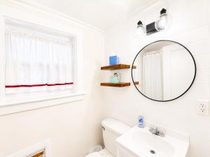 a white bathroom with a mirror and a sink at Cottage 8-9 - Stand Alone 2 Bedroom 2 Bath Private Courtyard Pet Friendly with Fee in Wolfeboro