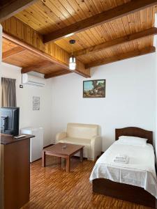 a bedroom with a bed and a couch and a tv at Kompleksi Jakaj in Velipojë