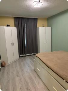 a bedroom with white cabinets and a bed in it at Mitte Drin! Nahe Düsseldorf in Hilden