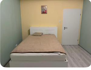 a small bedroom with a bed and a white door at Mitte Drin! Nahe Düsseldorf in Hilden