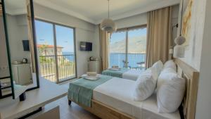 a bedroom with a bed with a view of the ocean at Adasya Hotel in Kaş