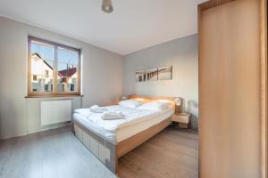 a bedroom with a large bed and a window at Bulwar Portowy, Sun & Snow in Ustka