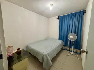 a small room with a bed and a blue curtain at Casa Real Santa Fe Cuernavaca in Atlacholoaya +9 photos