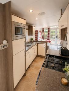 a kitchen with a sink and a stove at Brae Lodge Dollar in Dollar