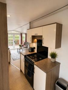 a kitchen with a stove and a counter top at Brae Lodge Dollar in Dollar