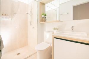 a bathroom with a toilet and a sink and a shower at Modern Broadbeach 2BR Apartment - Pet Friendly in Gold Coast